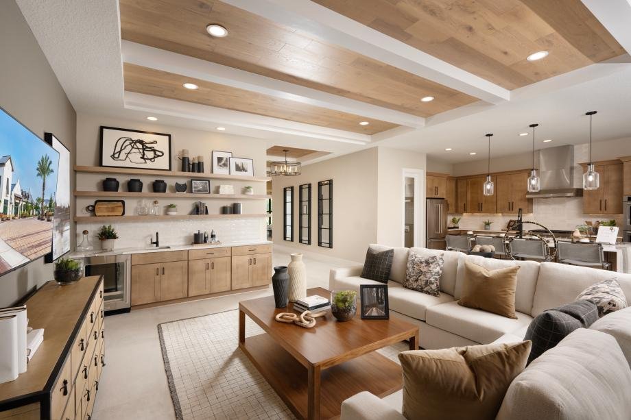 Great room and kitchen in the Selby model at Monterey, with a beamed wood ceiling and built-in beverage bar